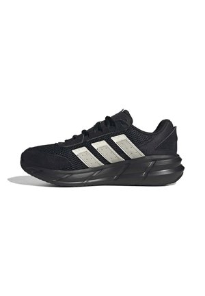 Zapato deportivo negro con tres rayas blancas en el lateral, parte superior de malla, suela gruesa y cordones negros mostrado desde el lado izquierdo.