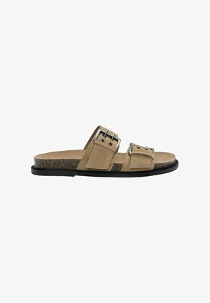 Sandales à glissière en suède beige avec deux brides réglables à boucles en argent, une semelle en liège et une semelle en caoutchouc noire.