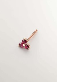 Piercing en oro rosa con tres piedras rojas redondas y facetadas dispuestas en un patrón triangular. Eje metálico liso. Sin hardware visible.