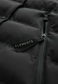 Schwarze Pufferjacke mit strukturiertem Obermaterial, Reißverschlusstasche und einem Stoffetikett mit "ELEMENTS" in weißer Schrift.