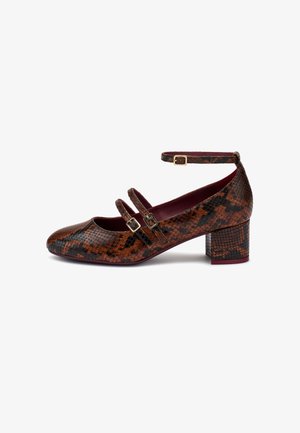 Des chaussures Mary Jane avec un talon bloc, présentant un extérieur en cuir imité serpent marron et noir, deux straps à boucle et une doublure intérieure lisse.