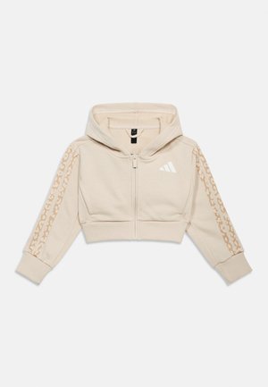 Krēmkrāsas puscikls ar rāvējslēdzēju un kapuci, ar ribotu aproču apdari un rakstainām bēša krāsas svītrām uz piedurknēm, uz krūtīm redzams balts logotips.