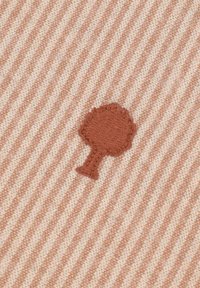 Tessuto di cotone con un motivo a righe in beige chiaro e pesca. Presenta un motivo di un albero ricamato marrone al centro.