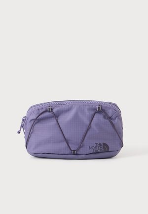 Malé obdĺžnikové fialové puzdro na zips s elastickými šnúrkami vpredu a čiernym logom The North Face na jednoduchom pozadí.