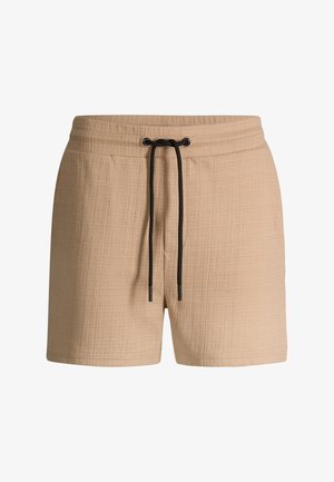 Short beige texturé avec une taille élastique et un cordon noir à nouer à l'avant.
