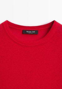 Roter Baumwollpullover mit geripptem Struktur und rundem Ausschnitt. Mit einem schwarzen Etikett mit der Aufschrift "Massimo Dutti" am Hals.