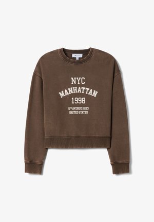 Felpa corta marrone con testo bianco che recita "NYC MANHATTAN 1998 5TH AVENUE 10133 STATI UNITI" in un font vintage. Tessuto morbido.