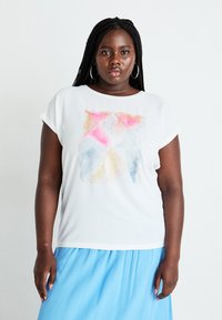 White short-sleeve top featuring a colorful abstract pattern in pink, blue, and yellow dots, paired with a flowing light blue pleated skirt.