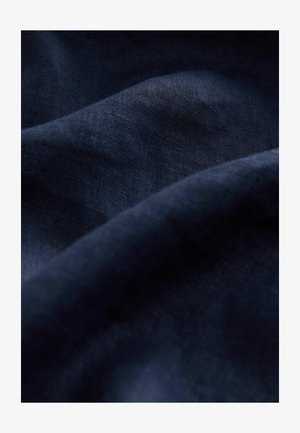 Dunkelmarineblaues Leinenmaterial mit einer strukturierten, leicht zerknitterten Oberfläche, die organische Drapierungen und einen sanften, subtilen Glanz präsentiert.