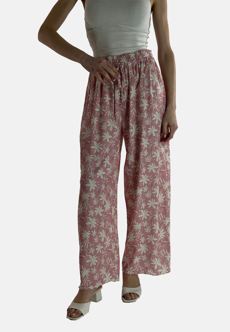 Roze bloemenpatroon palazzo broek met een losse pasvorm, voorzien van een elastische tailleband en lichte stof. Gecombineerd met witte hoge hakken.