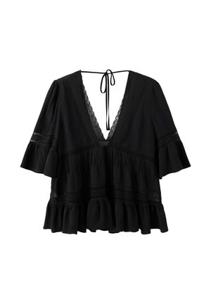 Blouse noire ample avec col en V profond, bordure en dentelle, manches évasées jusqu’au coude, ourlet à volants et fermeture à nouer au niveau de l’encolure arrière.