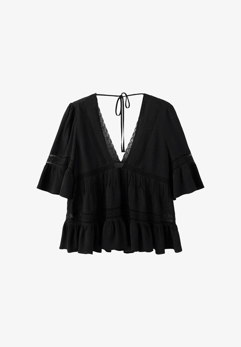 Blouse noire ample avec col en V profond, bordure en dentelle, manches évasées jusqu’au coude, ourlet à volants et fermeture à nouer au niveau de l’encolure arrière.