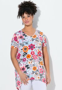 Camiseta floral con escote en V, mangas cortas y un patrón colorido de flores rosas, naranjas y negras sobre un fondo blanco.