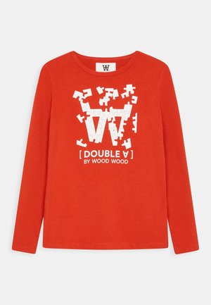 Czerwona koszula z długim rękawem z białą grafiką elementu puzzli tworzącego "WW" oraz tekstem "DOUBLE A BY WOOD WOOD" pod wzorem.