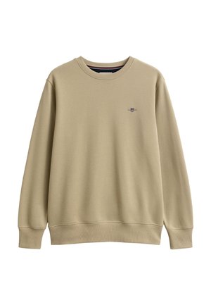 Beigefarbener Langarmpullover mit Rundhalsausschnitt, gerippten Bündchen und Saum, mit kleinem gesticktem Wappen auf der linken Brust.