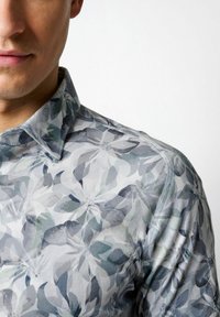 Musterhemd mit grauem und grünem Blumenmuster, Button-Down-Kragen und glatter Stoffoberfläche mit subtiler Satin-Optik.