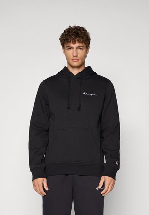 Sweatshirt à capuche noire avec tissu texturé, poche kangourou et logo blanc sur la poitrine. Cordons avec fermeture ajustable.