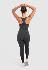 Zwarte sporttanktop en leggings, gevormde ontwerp, gladde textuur, met een racerback-stijl en minimalistische details.