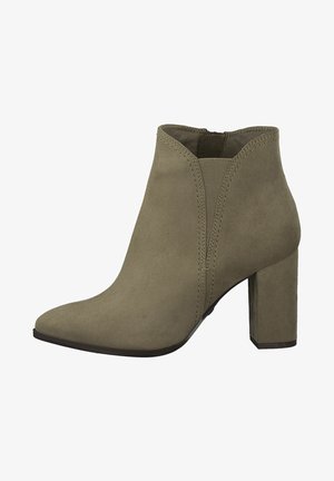 Stivaletto alla caviglia verde oliva in suede, con punta appuntita, pannelli laterali elastici e tacco spesso alto. Texture liscia con cuciture minime.