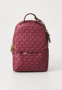 Zaino marrone scuro con motivo a logo MK su tutta la superficie, dettagli in hardware dorato e manico superiore. Tessuto liscio con scomparti con zip.