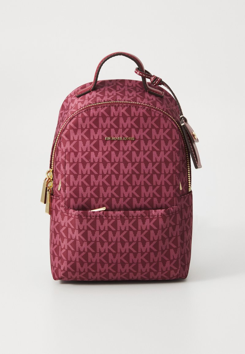 Zaino marrone scuro con motivo a logo MK su tutta la superficie, dettagli in hardware dorato e manico superiore. Tessuto liscio con scomparti con zip.