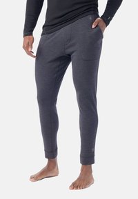 Mörkgrå joggers i mjukt material, med en figurnära design, elastiska muddar och frampocketar.