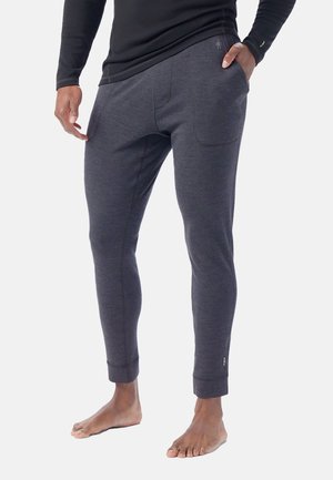 Mørkegrå joggingbukser lavet af blødt materiale, med en tætsiddende pasform, elastiske cuffs og forlommer.