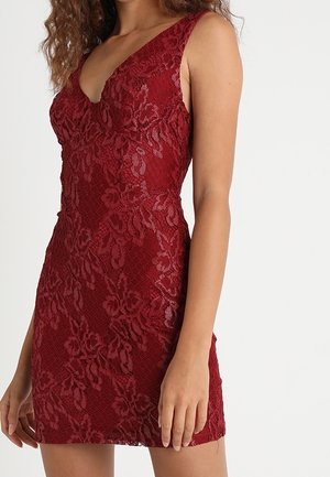 Bordeauxrode kanten jurk met een v-halslijn en mouwloos ontwerp. Voorzien van bloemmotieven en een aansluitend silhouet. Geaccentueerde textuur.