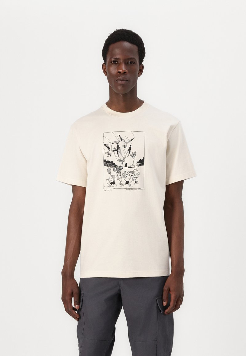 Cremefarvet t-shirt lavet af bomuld, med en sort grafisk print i en rektangulær ramme. Kortærmede og med rund halsudskæring.