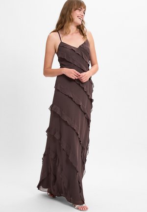 Langes, braunes, ärmelloses Kleid aus fließendem Stoff mit gestuften Rüschen. Das Kleid hat ein V-Ausschnitt-Design und reicht bis zum Boden.