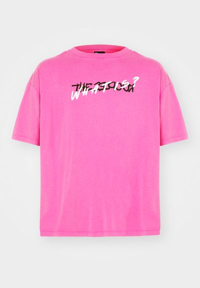 Světlá růžová trička s krátkým rukávem vyrobená z měkké látky. Má grafický potisk v černobílém textu na přední straně, který zní "CO JE?"