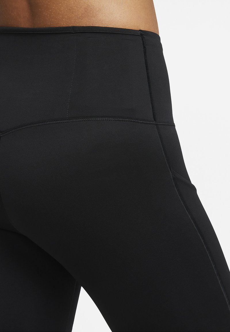 Zwarte leggings gemaakt van rekbaar materiaal, met een gladde textuur, hoge tailleband en vlakke naden voor comfort en ondersteuning.