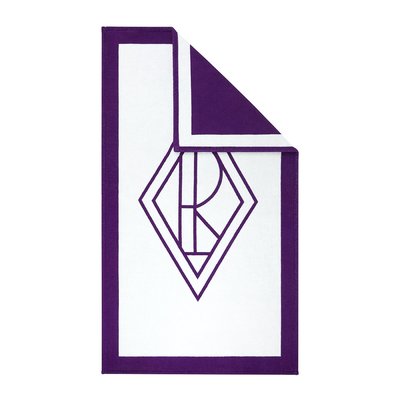 Asciugamano rettangolare bianco con bordo viola e design monogramma geometrico al centro, un angolo piegato per mostrare il lato posteriore viola solido.