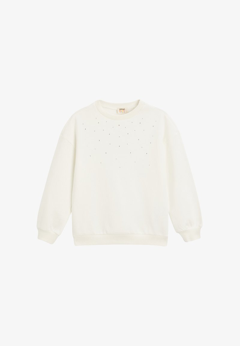 Sudadera blanca con cuello redondo, mangas largas y pequeños tachuelas decorativas en el frontal. Confeccionada en una tela suave con un corte holgado.