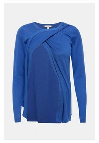 Modrý top s dlouhými rukávy z měkkého úpletu s drapovaným designem, všestranným vrstvením a jemnou texturou. Jemné žebrované detaily podél okrajů.