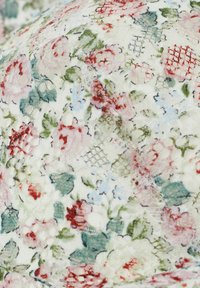 Bloemstof met een witte basis met lichtroze, rode en groene bloemen. Translucente textuur met verfijnde kantdetails en een gaaspatroon.