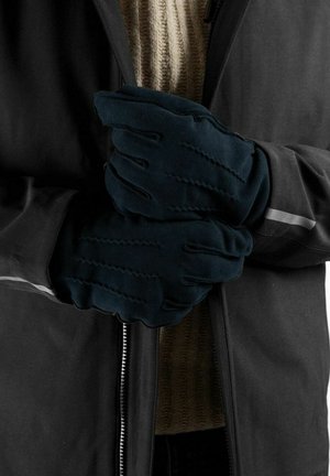 Donkerblauwe handschoenen van zacht materiaal, met een gestructureerd patroon en een aansluitend ontwerp, samengehouden voor een jas.