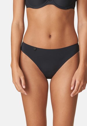 Black bikini bottoms in a smooth, matte fabric. Features a low-rise design with a small button accent on the left side. Minimalist style.