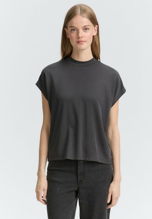 Top gris de manga corta con cuello alto, hecho de una tela suave. Corte holgado con un diseño de hombro caído y sin adornos visibles.