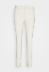 Pantalon slim, longueur cheville, de couleur écrue, avec passants de ceinture et fermeture éclair à l'avant, présenté sur un fond uni.