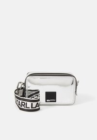 Borsa a tracolla metallica argento con forma rettangolare, dotata di una patch con logo nera e di una tracolla decorata con colori a contrasto.
