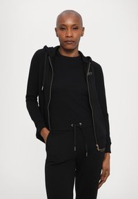 Armani Exchange TROUSER - Donji dijelovi trenirke - black/gold