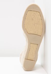 Beige espadrille sko med et teksturert stoffoverdel og en glatt gummisåle. størrelse 37 merket på sålen. Designet har en lett kile.