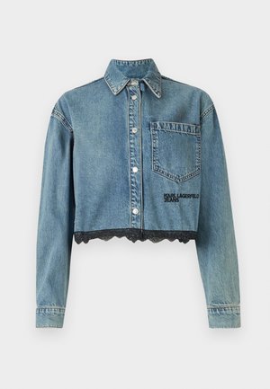 Veste en denim cropped de couleur bleu clair, avec un devant à boutons, un col pointu, une poche poitrine unique et un détail en dentelle noire au bas.