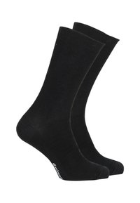 Chaussettes en coton noir présentant une texture côtelée, une hauteur de cheville standard, un renfort au niveau des orteils et un détail de logo subtil près de la cheville.