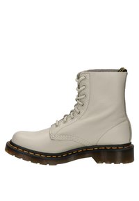 Bottine en cuir gris clair à lacets, coutures jaunes, semelle noire et languette à l'arrière.