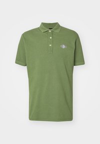 Polo verde de algodón, con cuello puntiagudo, tapeta de tres botones, mangas cortas y una insignia de logo en blanco y azul en el pecho.