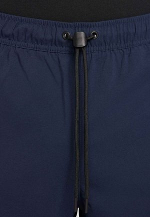 Navy blue swim shorts with an elastic waistband and black drawstring. Made of smooth fabric, featuring a simple, minimalist design.