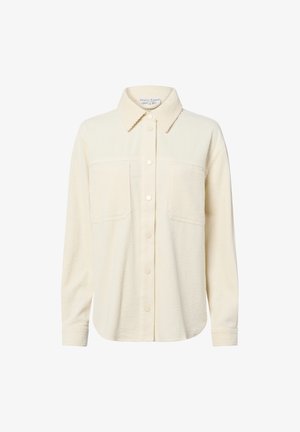 Camicia button-up color crema con texture a costine, due tasche sul petto e collare classico. Presenta bottoni chiari e maniche lunghe.