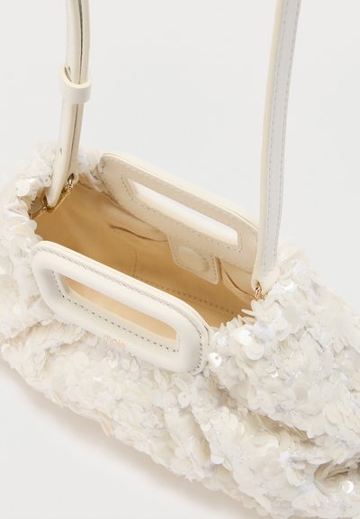 Λευκή τσάντα με ορθογώνιες λαβές κομμένες, καλυμμένη με λαμπερά λευκά παγιέτες, με λεπτό ιμάντα ώμου και επένδυση εσωτερικού σε ανοιχτό μπεζ χρώμα.
